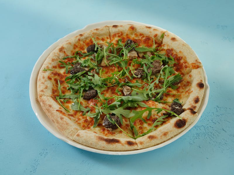 Mushroom truffle thin crust pizza with arugula